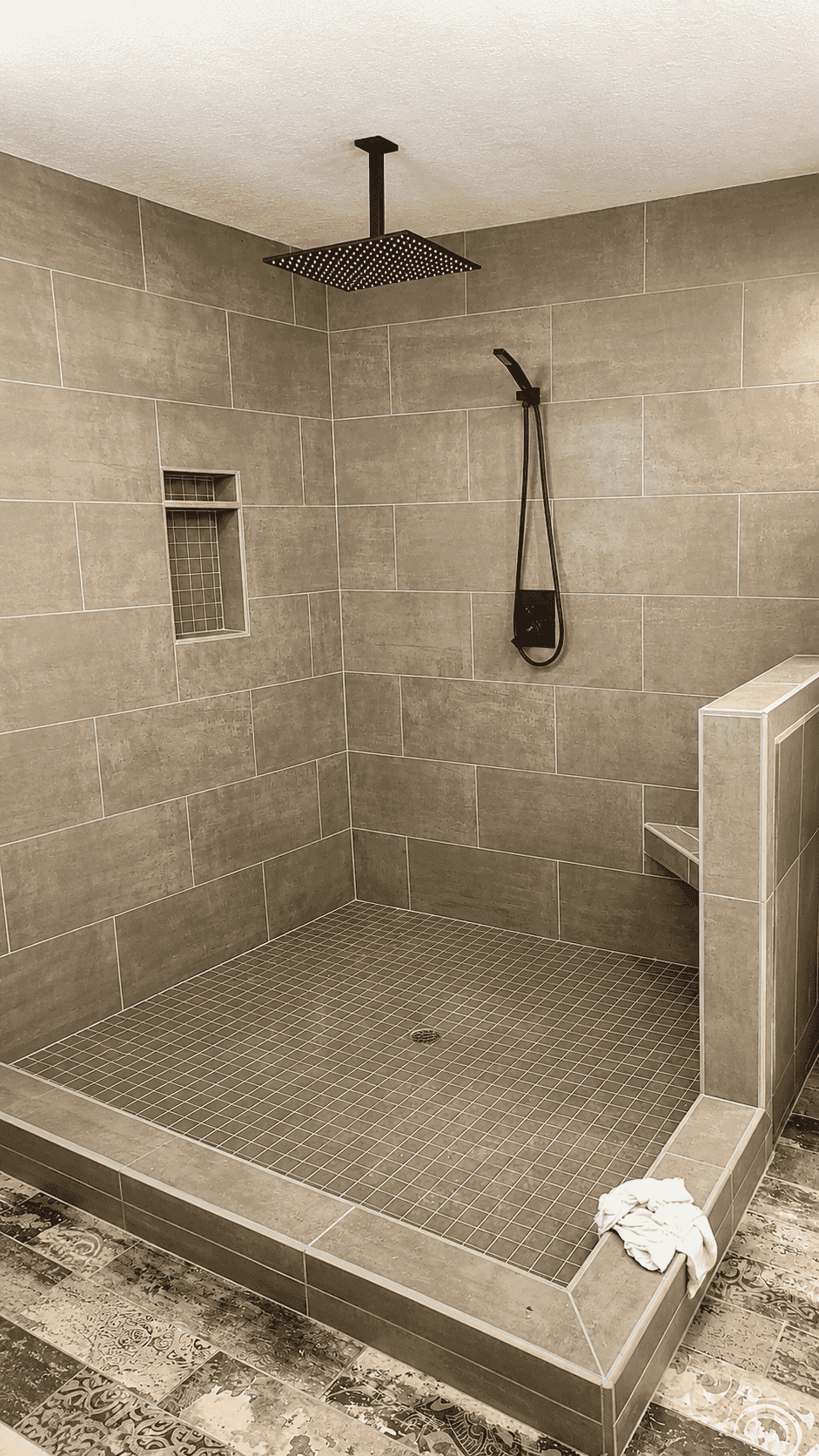 Tiled walk-in shower with a built-in bench, part of a bathroom remodel by Cademartori Construction